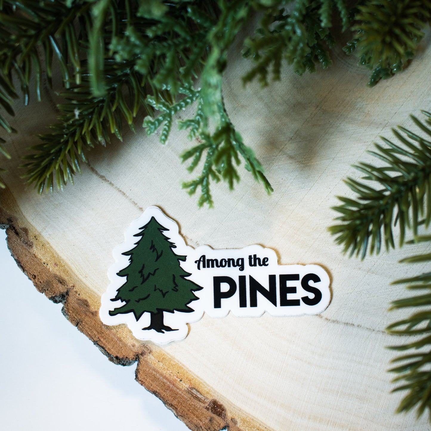 black outlined pine tree illustration with combination of  script and bold solid fonts